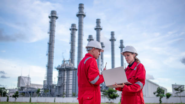 istock Engineers wearing safety gear, including hard hats examining survey a large blueprint tablet standing industrial facility gas or oil refinery engaged in a job requires high safety standards concept 2186572478