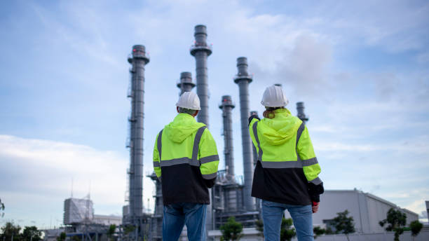istock Engineers wearing safety gear, including hard hats examining survey a large blueprint tablet standing industrial facility gas or oil refinery engaged in a job requires high safety standards concept 2186572555