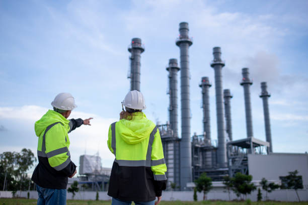 istock Engineers wearing safety gear, including hard hats examining survey a large blueprint tablet standing industrial facility gas or oil refinery engaged in a job requires high safety standards concept 2186572556