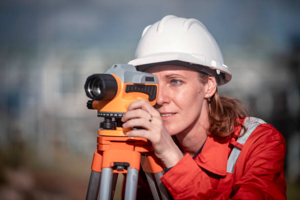 istock Surveyor engineers team wearing safety uniform and blueprint checking inspection by theodolite telescope to measurement level position railway construction site is industry transportation concept. 2186572572
