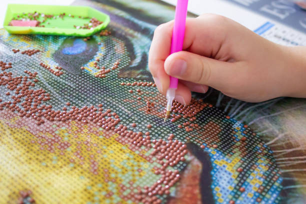 istock Creating colorful art with diamond painting using small beads and a stylus tool 2186575008