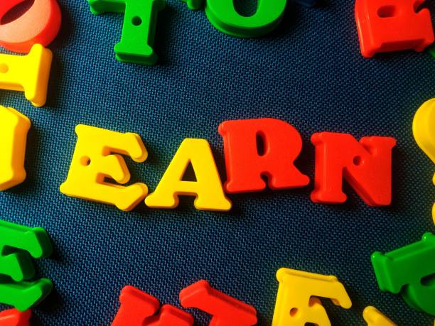 istock Word earn on alphabet 3d shape on blue texture background 2186577566