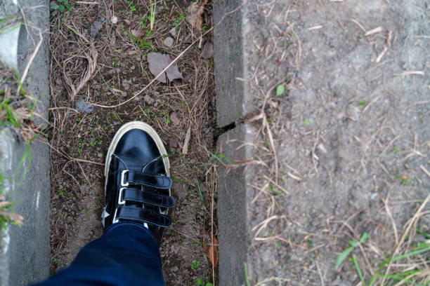 Feet with shoes that fell into the gutter