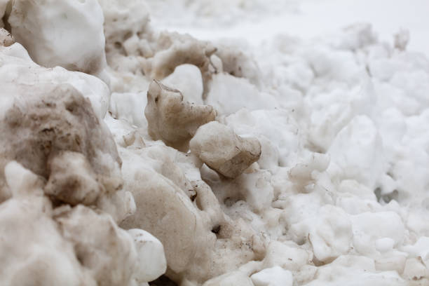 A pile of snow with some rocks in it. The snow is dirty and the rocks are white