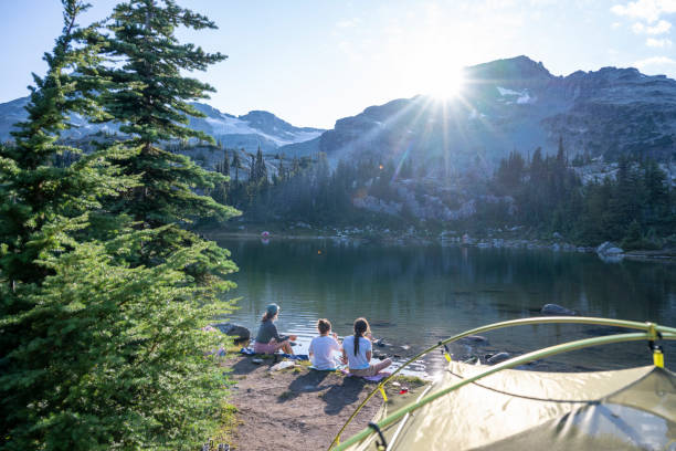 Mother and daughters on lakeshore by campsite
