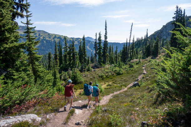 istock Mother and daughters backpack on mountain trail 2186582935