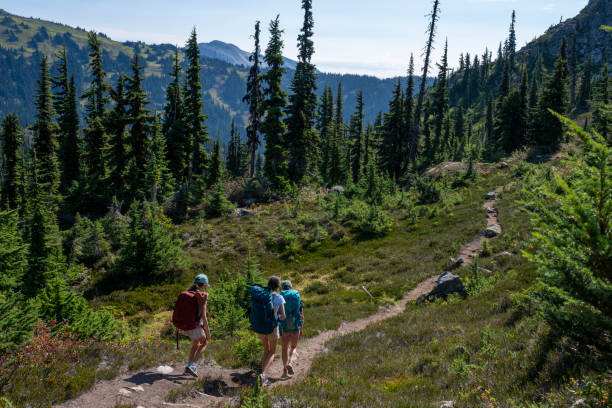 istock Mother and daughters backpack on mountain trail 2186582943