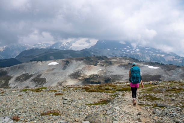 istock Young woman backpacks on alpine trail 2186583052