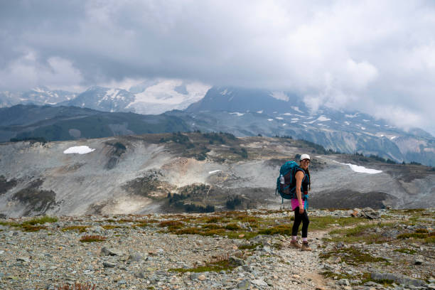 istock Young woman backpacks on alpine trail 2186583109