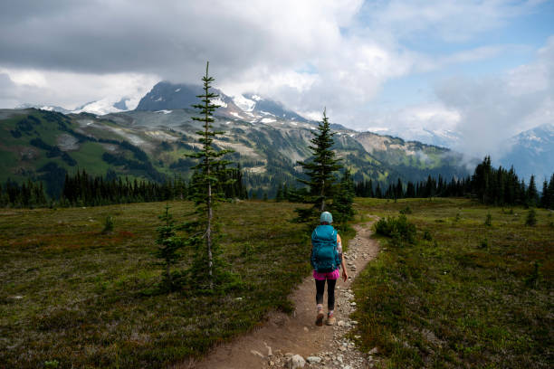 istock Young woman backpacks on alpine trail 2186583110