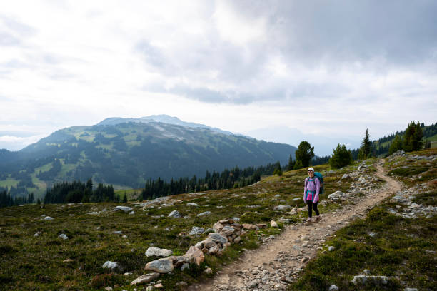 istock Young woman backpacks on alpine trail 2186583208