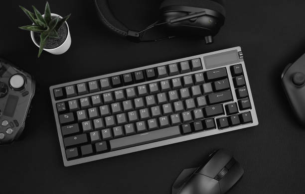 istock gamer work space concept, top view a gaming gear, mouse, keyboard, joystick, headset, mobile joystick, in ear headphone and mouse pad on black table background. 2186585257