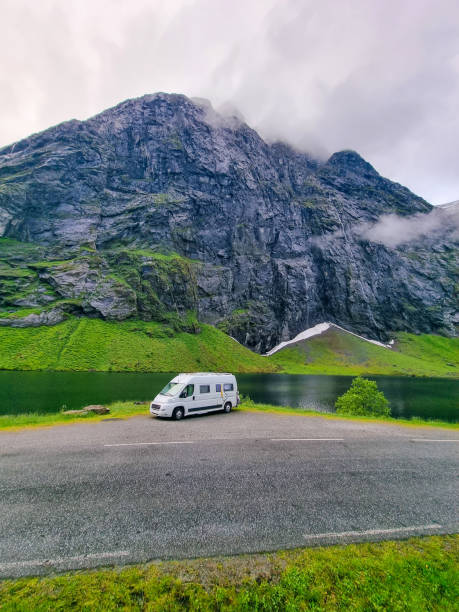 istock A serene camper van parked by a tranquil lake against majestic mountain backdrop at dawn 2186590242