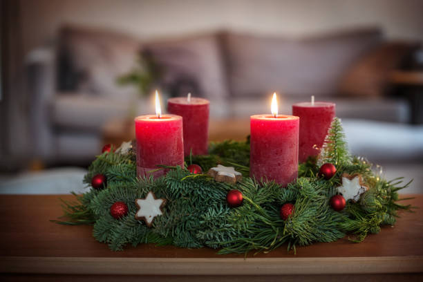 istock Second Advent, green wreath with Christmas baubles, cinnamon star cookies and red candles, two are lit, on a table in the living room, copy space, selected focus 2186592302