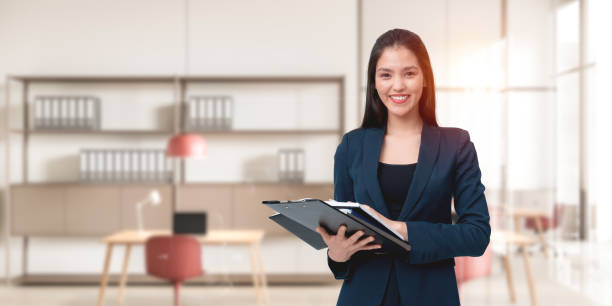 istock Businesswoman smiling while holding documents in a modern office 2186592535