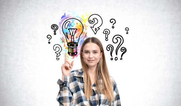 istock Woman pointing with colorful lightbulb and question marks in bac 2186592585