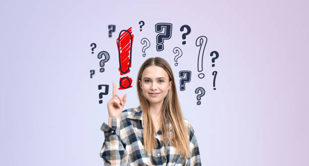 istock Smiling woman finger point at question marks on purple background 2186592663