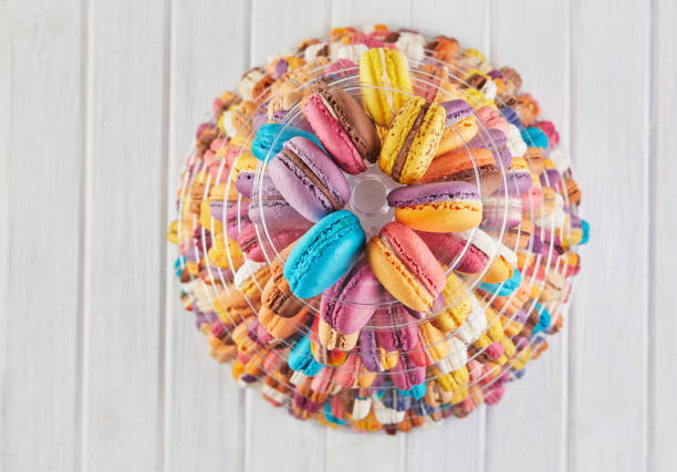 A top-down view of colorful macarons arranged in a circular pattern, showcasing their delicate textures and pastel hues.