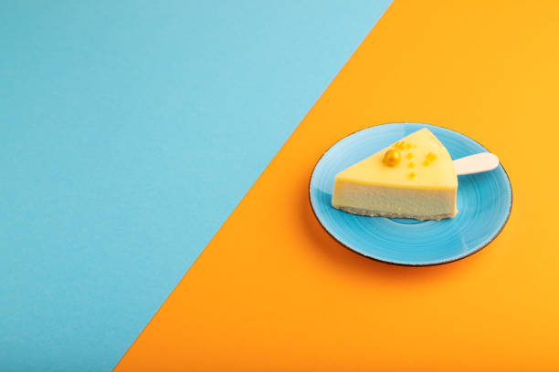 istock Yellow Cake pop with sprinkles on blue ceramic plate on blue and orange pastel paper, side view, copy space 2186594214