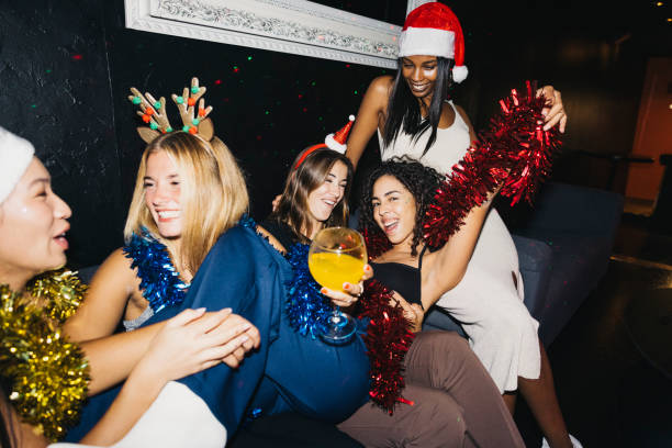 A group of joyful friends enjoying a Christmas celebration  in a night club with tinsel and Santa hats. The festive atmosphere is highlighted by laughter, holiday accessories, and bright decorations.