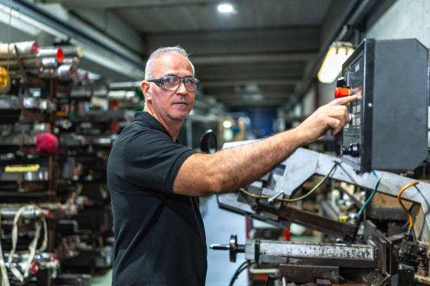 istock Man operating in the control panel of a mechanical saw 2186601534