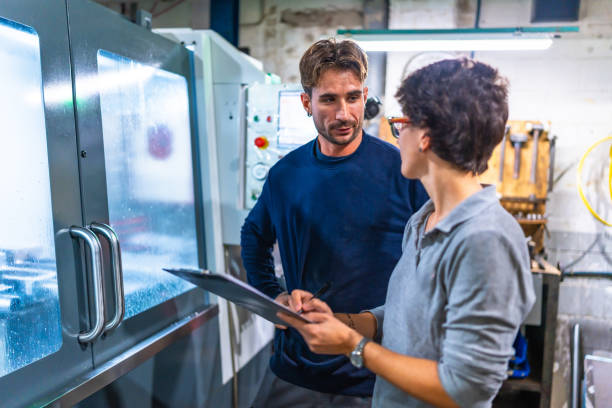 istock Female manager and manual worker talking in a factory 2186601728