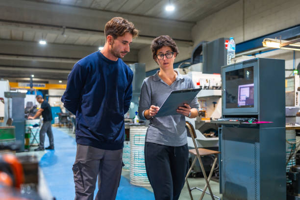 istock Manager and engineer doing paperwork standing and talking at factory 2186601730