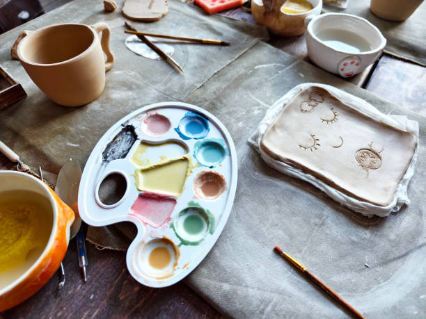 istock Workshop for kids. Children learning how to use clay for making dishes. 2186602113