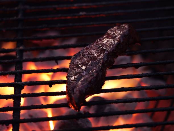 Juicy steak grilling over open flames.