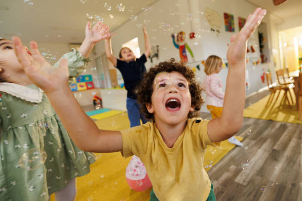 istock Boy having fun playing whit bubbles whit his friends indoors 2186606736