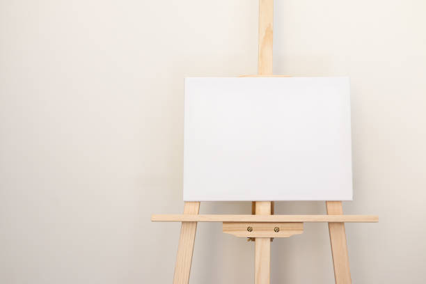 istock A white blank canvas on an easel standing on the right against wall, copy space on left. Blank page, creativity, imagination, art, painting concept 2186606764
