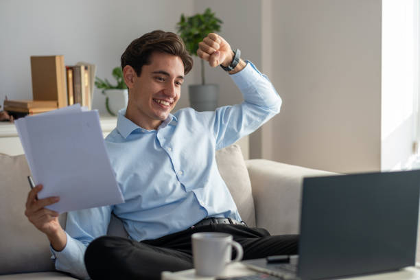 istock Young businessman celebrating success while working from home 2186613419