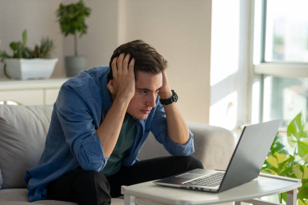 istock Stressed young man working from home holding head in hands 2186613580