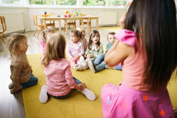 istock Children sit in a circle while the animator tells them stories 2186614202