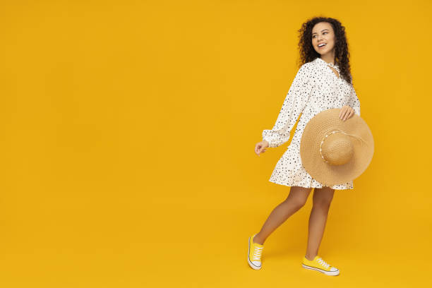 istock Young woman with hat on yellow background 2186616709