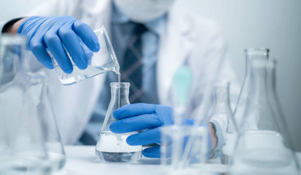istock Hands holding pouring fluid liquid beaker flask test tube glassware sample laboratory for compare in medicine chemical biology medical medicine science experiment technology analysis 2186616988