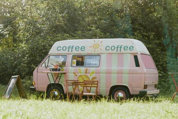 Pastel colored food truck with fully equipped zone for clients and their orders parked in local forest