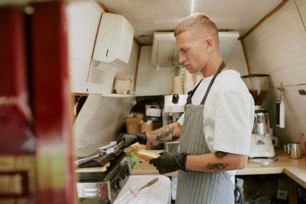 istock Professional Young Adult Cook Preparing Hot Dog 2186618492
