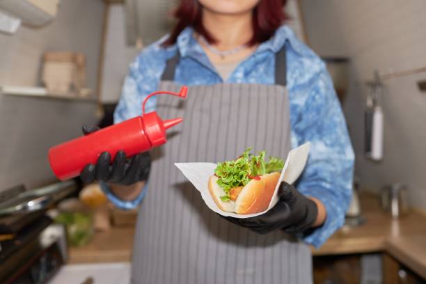 istock Cook with Hot Dog and Ketchup in Hands 2186618736