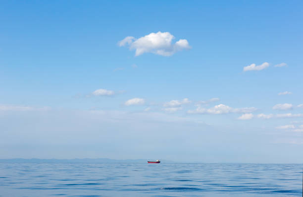 Seascape. Blue ocean,  clear sky, ship on  horizon. Beautiful seascape with cloud on a sunny day. Pacific Ocean.