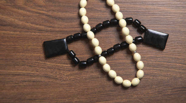 Rosary beads on the wooden background.