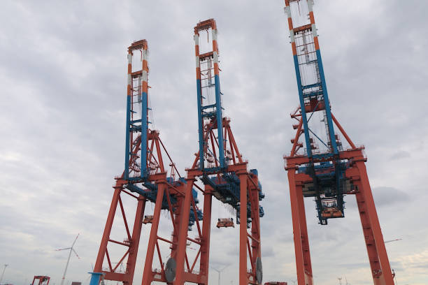 Hamburg, Germany - 09 16 2024: Towering gantry cranes in red and blue against the sky.