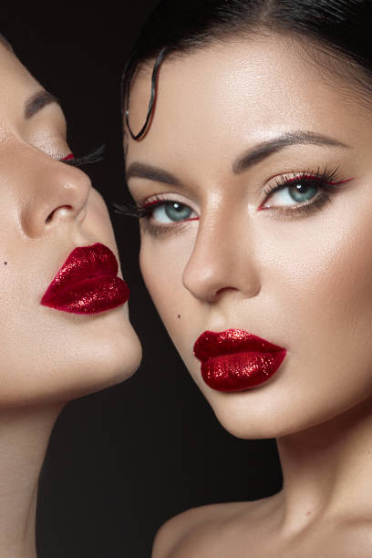 istock Two models display bold red lips and intricate makeup, highlighting the artistry of cosmetics. perfect lighting accentuates their features, creating an alluring beauty moment 2186633049