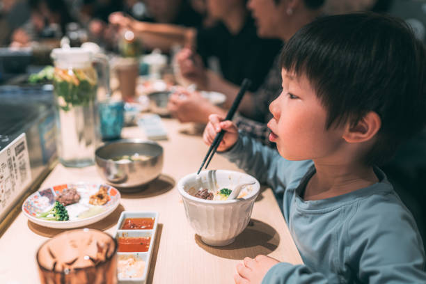 istock Lovely little boy having meal joyfully in restaurant 2186634872