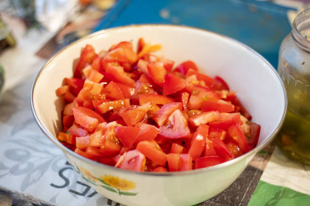 Red tomatoes finely chopped in a deep plate for preparing vegetable salad