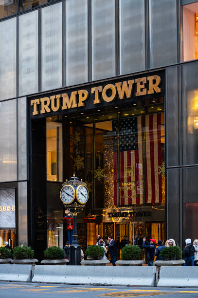 New York City, United States - December 6, 2023: The main entrance of the Trump Tower. 5th avenue Trump Tower with the gold name and clock. Pedestrians walking on the street
