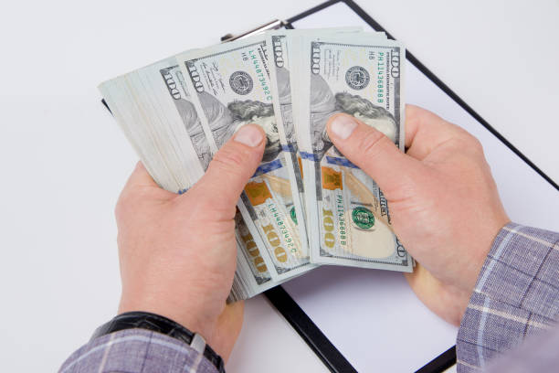 istock man holding banknote and counting money 2186650980
