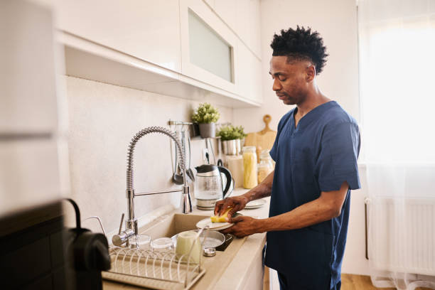 istock Nurse Man Washing Dishes in a Modern Kitchen Setting 2186652413
