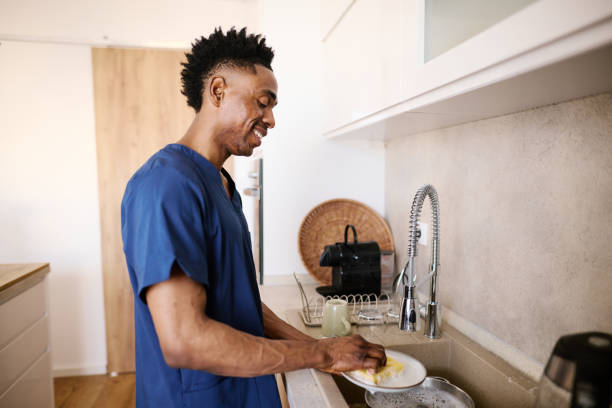 istock Nurse Man Washing Dishes in a Modern Kitchen Setting 2186652427