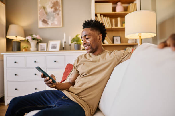 istock Relaxed Black Man Using Smartphone in Cozy Living Room Setting 2186652441